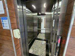 un ascensor en un edificio con una puerta de cristal en Pousada Santa Gianna, en Aparecida