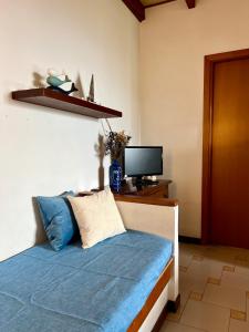 um quarto com uma cama e uma televisão numa secretária em Appartamento con accesso privato spiaggia em Savona