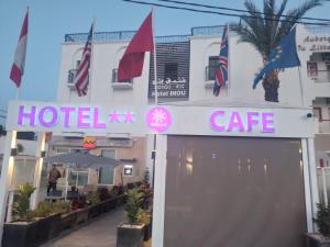 a hotel cafe with flags in front of a building at Hotel INOU in Agadir