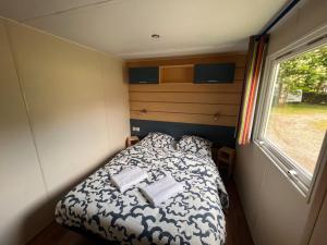 a small bed in a small room with a window at Le Muscat - Mobilhome pour 5 - TV - Climatisé in Boofzheim