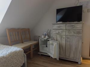 1 dormitorio con vestidor y TV de pantalla plana. en Edvy Malom Fogadó Barokk Udvarház, en Pápa