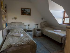 1 dormitorio con 2 camas y escalera en Edvy Malom Fogadó Barokk Udvarház en Pápa