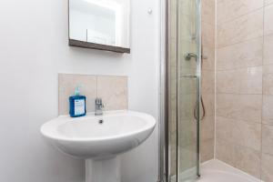 a bathroom with a sink and a shower at Flat 5- Cozy Studio Flat in The Heart of Crawley in Crawley