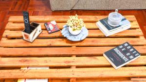 una mesa de café de madera con libros y una flor en ella en Apartamento Palácio Quitandinha, en Petrópolis