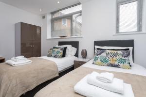 a bedroom with two beds with towels on them at Studio Flat in the Heart of Crawley- Apartment 5 in Crawley