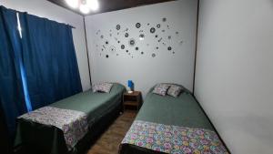 a room with two beds and a clock on the wall at Brisas de Killa in General Rodríguez +22 photos