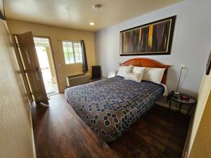 a bedroom with a bed with a blue comforter at California Suites Motel in Calexico