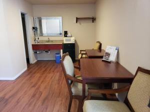 CalexicoにあるCalifornia Suites Motelのテーブル、椅子、シンクが備わる客室です。