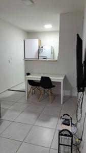 a white desk with a chair and a microwave at Apto inteiro - WiFi, ar condicionado, Piscina in Cuiabá