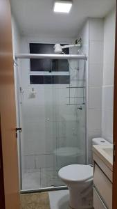 a bathroom with a glass shower with a toilet at Apto inteiro - WiFi, ar condicionado, Piscina in Cuiabá