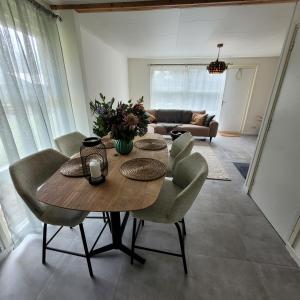 un soggiorno con tavolo e sedie in legno di Ecolodges De Dreef Guesthouse a Renesse