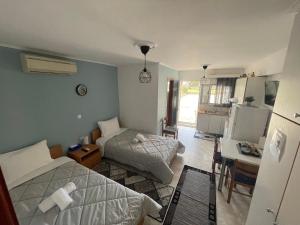 a bedroom with two beds and a desk and a kitchen at Flo's Apartments in Missolonghi