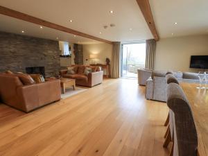 ein großes Wohnzimmer mit Sofas und einem Kamin in der Unterkunft Keepers Cottage in Ulverston