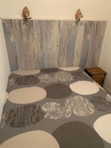 a room with a bed with a bedspread on it at Appartement plage sables blancs in Douarnenez