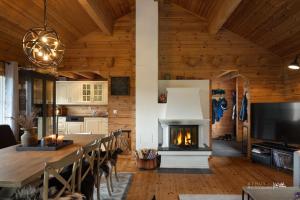 ein Wohnzimmer mit Kamin und einem Tisch mit Stühlen in der Unterkunft Nesfjellet in Nos