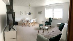 a living room with a couch and a table and chairs at Ferienhaus im Grünen in Weimar
