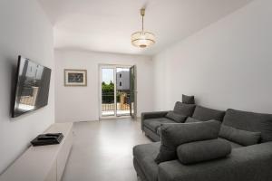 a living room with a couch and a tv at Luxury Apartments Villa San Avia in Banjole