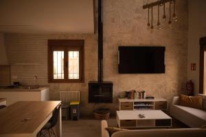 a living room with a couch and a tv on the wall at La Casina de Palacio in Galisteo