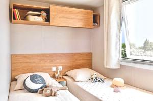 a small bedroom with two beds with stuffed animals on them at Camping de Pallegarste Villa 141 in Mariënberg