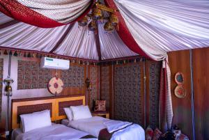 a tent with two beds in a room at Wadi Rum Majestic Camp in Wadi Rum