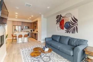 sala de estar con sofá azul y cocina en Park City Modern New Park City Townhome, en Park City