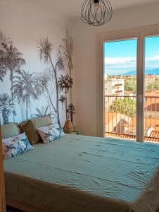 - une chambre avec un grand lit recouvert de palmiers dans l'établissement Le Panoramique - T2 46m² - Proche centre-ville et gare, à Perpignan