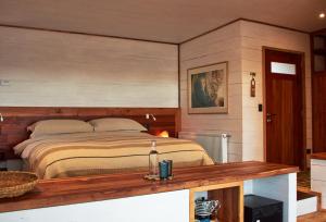 a bedroom with a bed and a wooden table at Cuarzo Lodge in Pichilemu