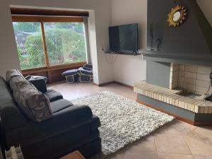een woonkamer met een bank en een open haard bij Apartamento no centro de Gramado in Gramado