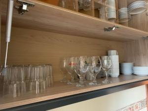 een rij wijnglazen op een plank bij Apartamento no centro de Gramado in Gramado
