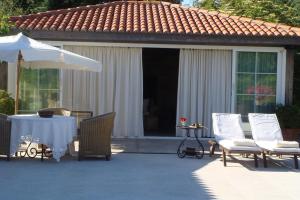 een patio met een tafel en stoelen en een parasol bij Finca A Coutada. in Celanova