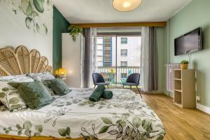 a bedroom with a bed with two chairs and a television at Studio Victoria in Aix-les-Bains