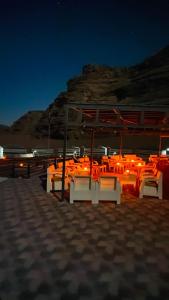 a group of chairs sitting on the beach at night at Wadi Rum Majestic Camp in Wadi Rum