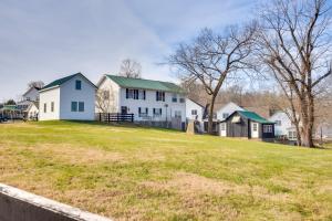 une maison blanche avec un toit vert sur une pelouse dans l'établissement Cumberland Cottage - 2 Blocks to Downtown Dover!, à Dover