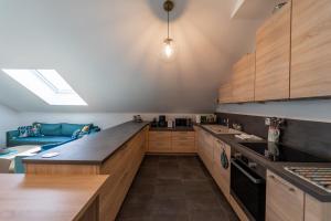 une cuisine avec des placards en bois et un canapé bleu dans l'établissement La Champanaise - 2 bedroom apartment 300m from Lake Annecy, à Duingt