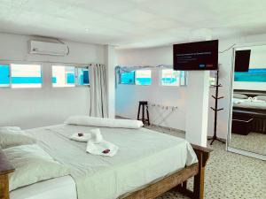 a bedroom with a bed with a teddy bear on it at Flats e Suítes Elcaline in Porto De Galinhas