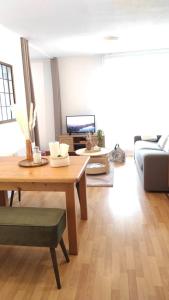 a living room with a table and a couch at Cosy du Birdie Logement 4 pers avec piscine in Giez