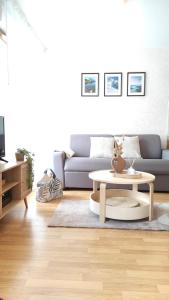 uma sala de estar com um sofá e uma mesa de centro em Cosy du Birdie Logement 4 pers avec piscine em Giez