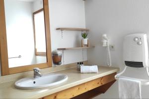 a bathroom with a sink and a large mirror at Cosy du Birdie Logement 4 pers avec piscine in Giez