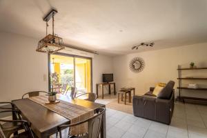 een woonkamer met een tafel en een bank bij location de vacances figuier avec jardin barbecue piscine chauffée à Calvi in Calvi