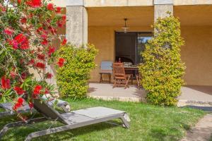 een patio met een tafel, stoelen en bloemen bij location de vacances figuier avec jardin barbecue piscine chauffée à Calvi in Calvi