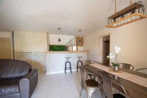 een keuken en een woonkamer met een tafel en stoelen bij location de vacances figuier avec jardin barbecue piscine chauffée à Calvi in Calvi