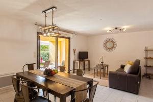 een eetkamer en een woonkamer met een tafel en stoelen bij location de vacances figuier avec jardin barbecue piscine chauffée à Calvi in Calvi