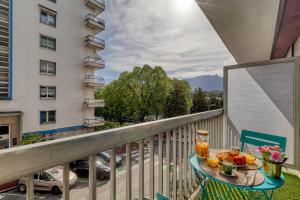 - un balcon avec une table et un bol de fruits dans l'établissement Studio Victoria, à Aix-les-Bains