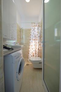 a bathroom with a washing machine and a toilet at Villa e Olsi Kacupaj in Sarandë