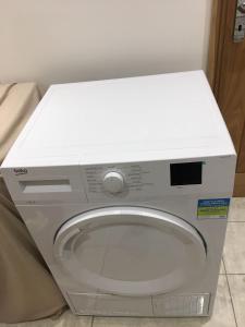 eine Waschmaschine mit weißem Oberteil im Bad in der Unterkunft Private room renovated with standard size brown desk in SE9 6PG in London