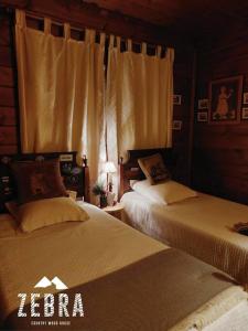 1 dormitorio con 2 camas y ventana en Zebra Country Wood House en Arcos de Valdevez