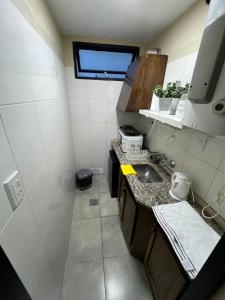 eine kleine Küche mit Spüle und Fenster in der Unterkunft Rivadavia Departamentos in Mendoza