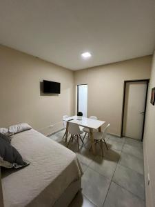 ein Schlafzimmer mit einem Bett und einem Tisch mit Stühlen in der Unterkunft Rivadavia Departamentos in Mendoza