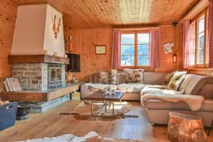 a living room with a couch and a fireplace at Chalet Castellani Duplex in Fiesch