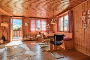 a dining room with a table and chairs and windows at Chalet Castellani Duplex in Fiesch